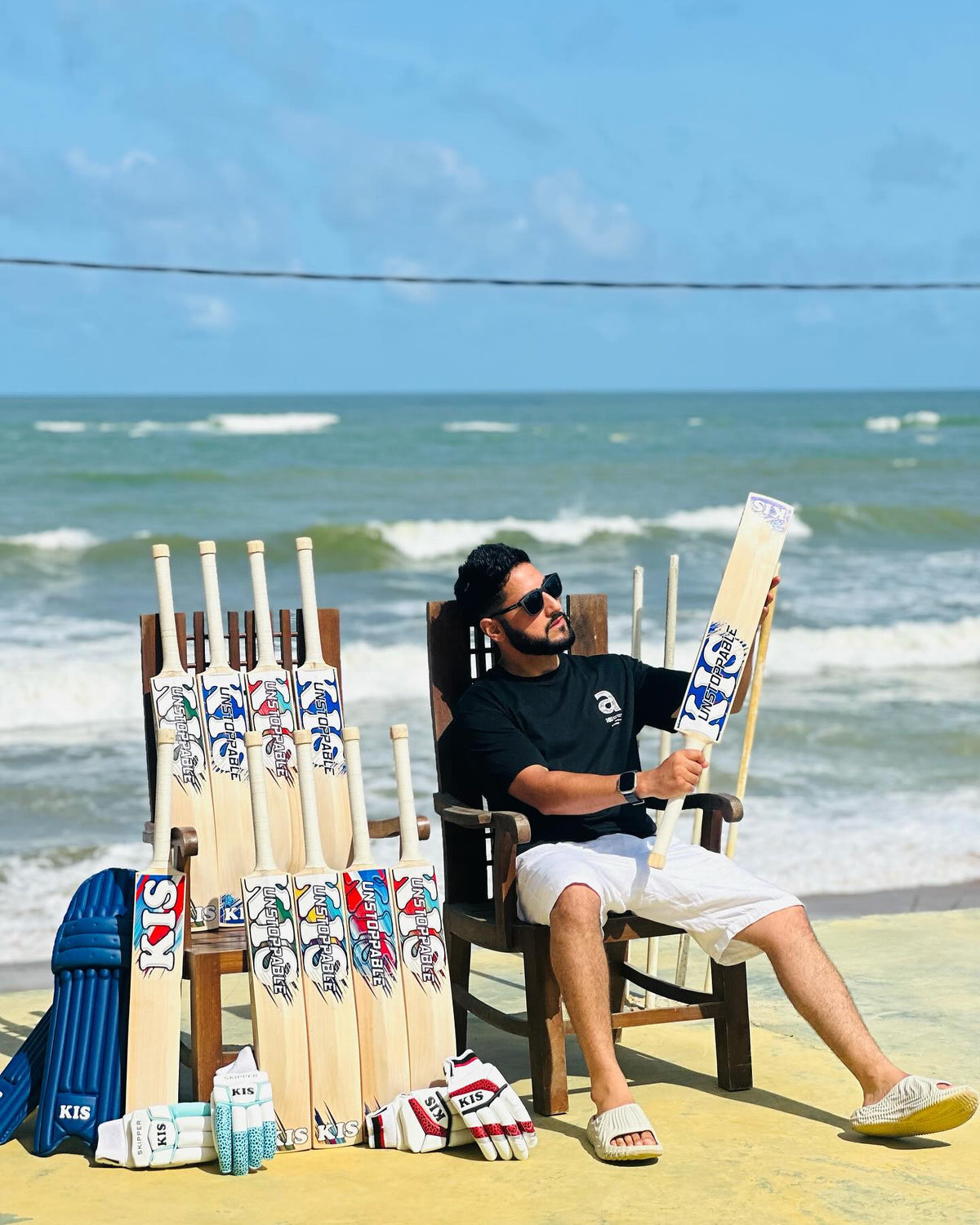 Man sitting on a beach with best kashmir willow cricket bats, kis bats and hard hitting bats of kashmir willow